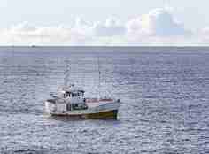 liten sjark på havet med snøkledde fjell i horisonten