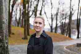 kvinne i sort kåpe i en park med høstfarger