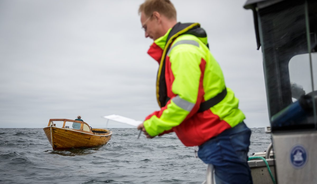 bilde av forsker i båt på sjøen som intervjuer fritidsfiskere